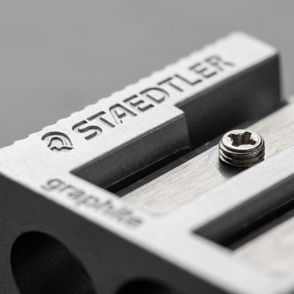 A macro inspection of a STAEDTLER metal sharpener, showing the debossed logo and a screw.