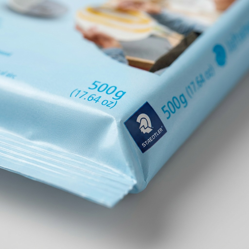 A super-macro view of the textured laminate pouch for STAEDTLER Fimoair 500g clay, showing fine material details and a precision heat seal.
