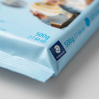 A super-macro view of the textured laminate pouch for STAEDTLER Fimoair 500g clay, showing fine material details and a precision heat seal.