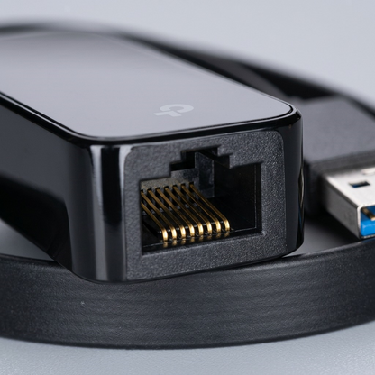 Macro detail of the gold-plated pins within the RJ45 port of the TP-Link UE306 adapter.
