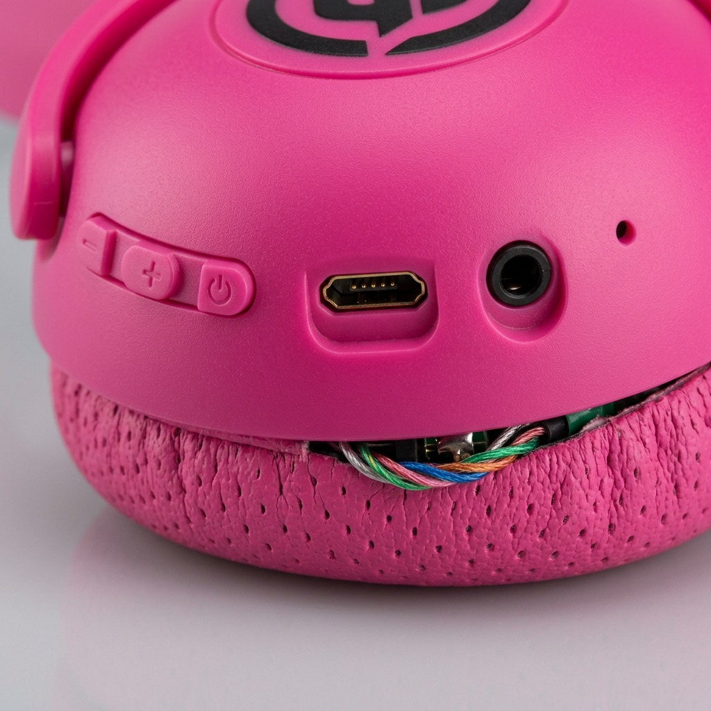 A detailed macro photo of Wicked Audio Tricky Tike headphones showing the button controls, ports, and mic.