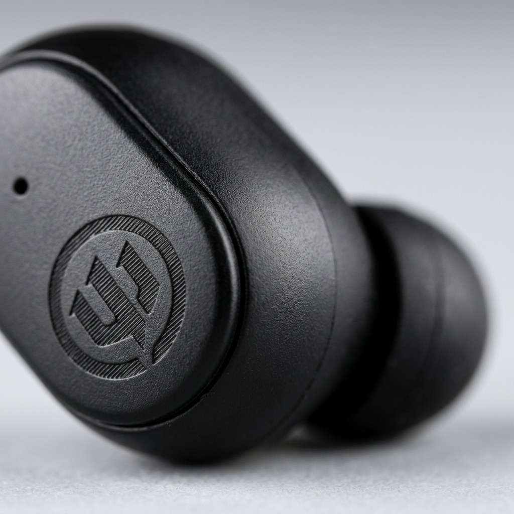 Macro view of the Wicked Audio Embr earbud's textured matte finish and laser-etched logo.