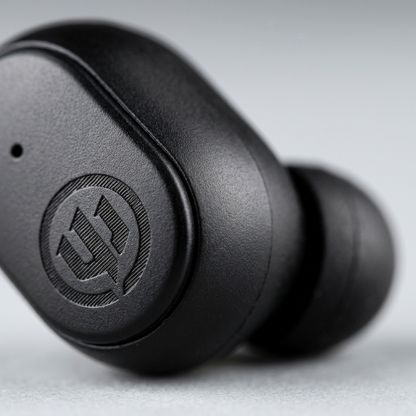 Macro view of the Wicked Audio Embr earbud's textured matte finish and laser-etched logo.