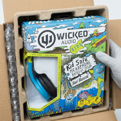 A premium close-up view showing the Wicked Audio Rad Rascal headphone box securely nestled within custom-molded protective air cushions inside a durable corrugated cardboard shipping case, ensuring damage-free delivery.