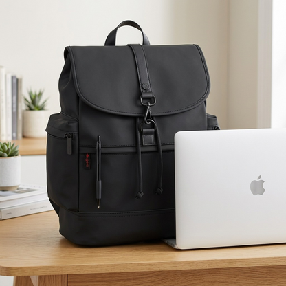 Bugatti Edition22 Core Backpack in black vegan leather shown on a desk next to a laptop for scale.