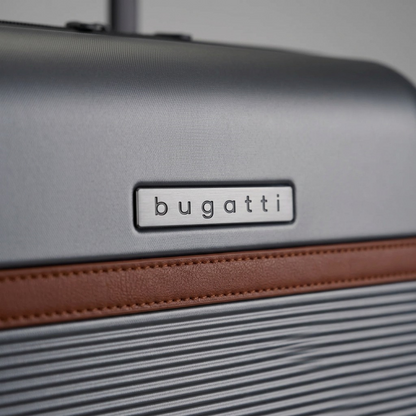 Macro detail of Bugatti Wellington luggage showing the metal logo plate and vegan leather trim.