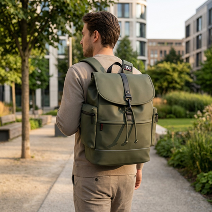 A man wearing the khaki Bugatti EDITION22 Core Backpack while walking through a sunny urban park.