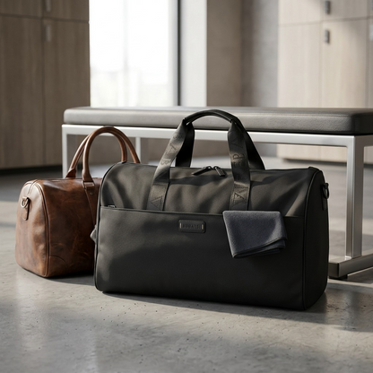 Black Bugatti Reborn convertible duffle bag on a locker room floor next to a leather bag and bench.