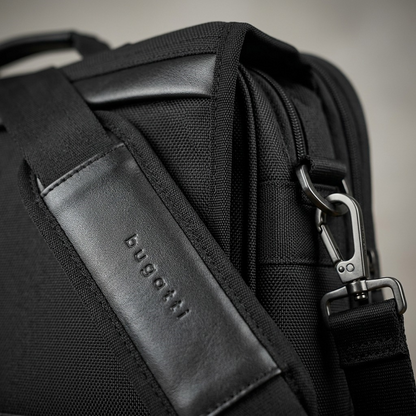 Macro detail of Bugatti Gregory Briefcase showing the embossed logo, vegan leather, and metal clip.