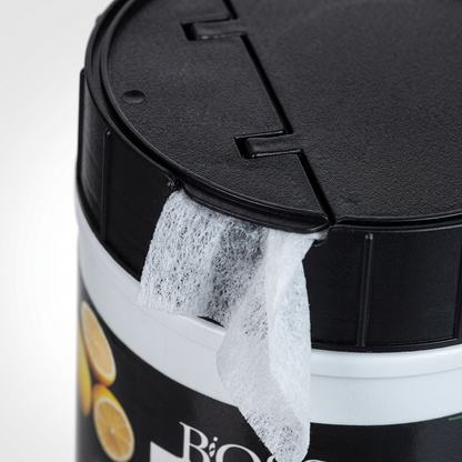 Macro view of a white BiOSS disinfecting wipe emerging from the black dispenser lid of a canister.