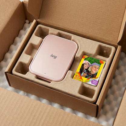 A Canon IVY 2 Mini Photo Printer in Blush Pink is unboxed with protective inserts.