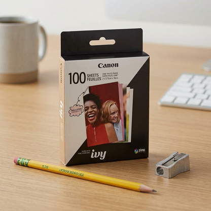 Scale reference photo for Canon ZINK 100-pack photo paper, shown next to a common pencil and sharpener for clear size understanding.