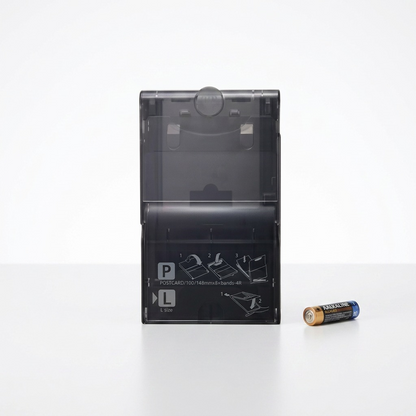 A photo of the Canon PCPL-CP400 paper cassette next to a standard AA battery.