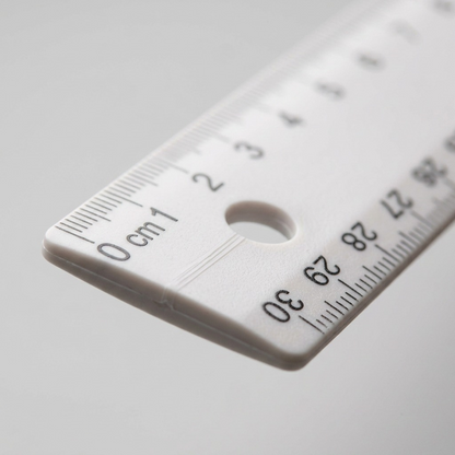 Extreme close-up of a Westcott 30cm ruler, focusing on the centimeter markings (0-2) and the circular hanging hole on the white plastic.