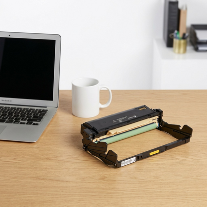 Xerox drum cartridge and coffee mug on a wooden desk with a MacBook Air.