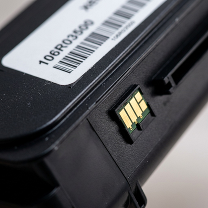Macro shot of gold-plated contacts and model number 106R03500 on a black Xerox toner cartridge.
